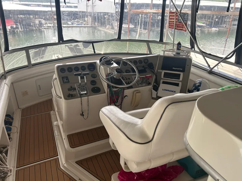 Slide: The Image of 1996 Carver 440 Aft Cabin Motor Yacht helm with steering wheel and navigation equipment. - 42