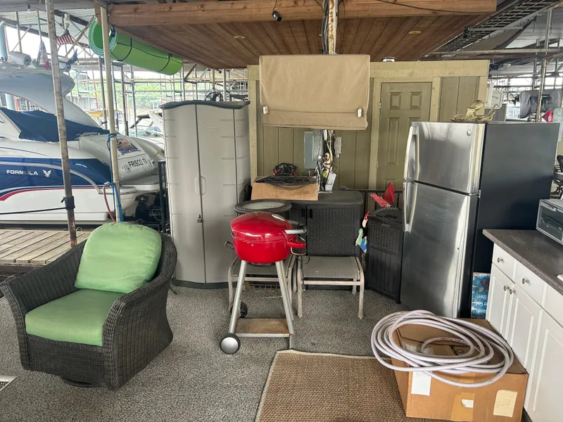 Slide: The Image of Cozy dock setup with grill, chairs, and storage near 1996 Carver 440 Aft Cabin Motor Yacht. - 11