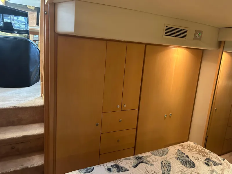 Slide: The Image of 1996 Carver 440 Aft Cabin Motor Yacht interior with wooden cabinetry and patterned bedding. - 30