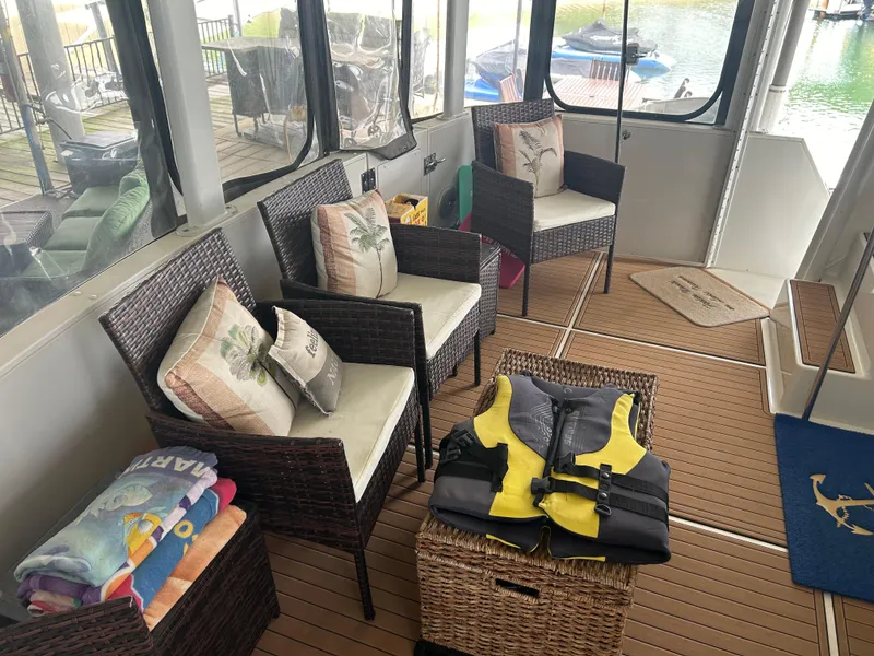 Slide: The Image of 1996 Carver 440 Aft Cabin Motor Yacht interior with wicker chairs, life jackets, and colorful towels. - 44