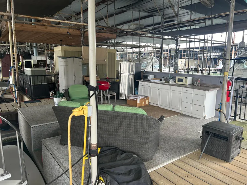 Slide: The Image of Outdoor dock setup with seating, kitchen area, and appliances near a 1996 Carver 440 Aft Cabin Motor Yacht. - 6