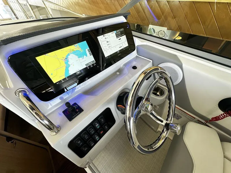 Slide: The Image of 2024 Regal 26XO boat helm with modern navigation system and chrome steering wheel. - 12