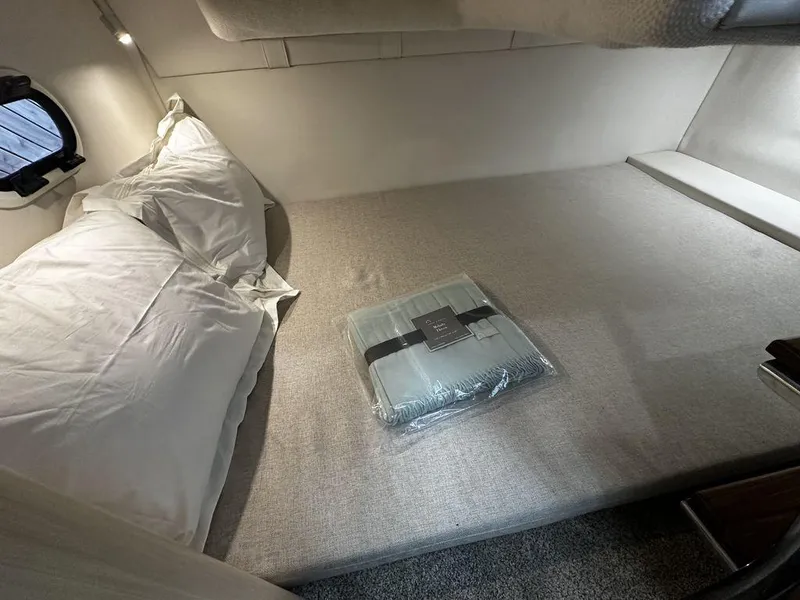 Slide: The Image of 2024 Regal 26XO cabin bed with pillows and packaged bedding. - 14