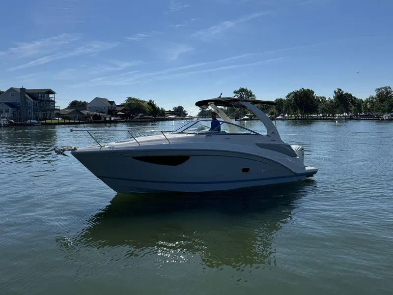 Slide: The Image of 2024 Regal 26XO boat cruising on a serene lake under a clear blue sky. - 19
