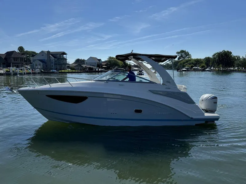 Slide: The Image of 2024 Regal 26XO boat on a serene lake with houses in the background. - 20