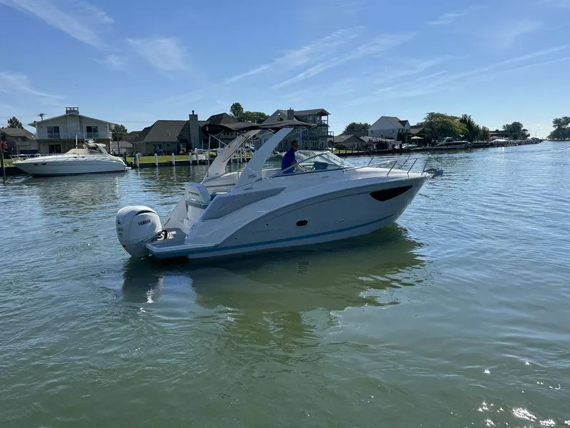 Slide: The Image of 2024 Regal 26XO boat on calm water near residential docks. - 22