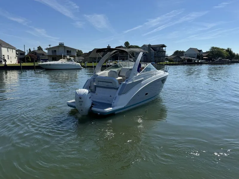 Slide: The Image of 2024 Regal 26XO boat on calm water near waterfront homes. - 23
