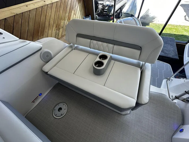 Slide: The Image of 2024 Regal 26XO boat interior with cushioned seating and cup holders. - 8