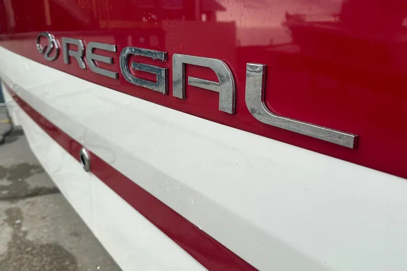 Slide: The Image of Close-up of 2019 Regal 26 OBX boat logo on red and white hull. - 10