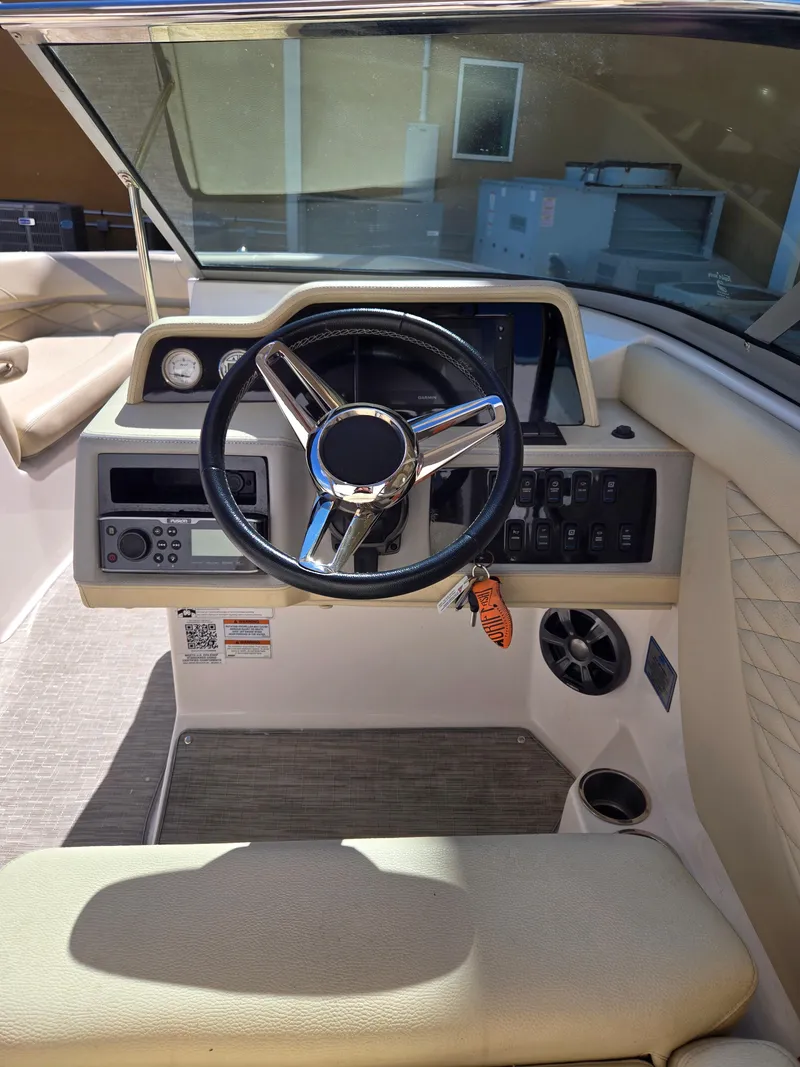 Slide: The Image of 2019 Regal 26 OBX boat cockpit with steering wheel and control panel. - 16