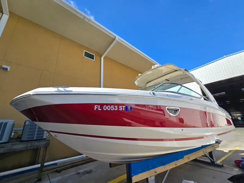 Slide: The Image of 2019 Regal 26 OBX boat with red and white exterior, docked near a building. - 18