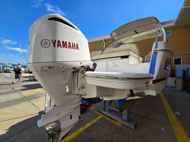 Slide: The Image of 2019 Regal 26 OBX boat with Yamaha outboard motor, docked under clear blue sky. - 22