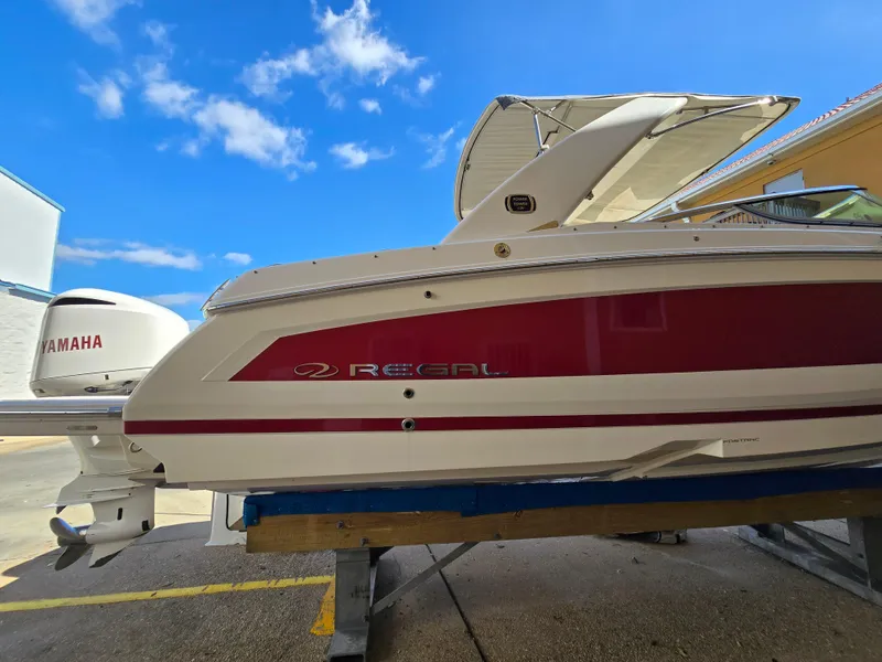 Slide: The Image of 2019 Regal 26 OBX boat with Yamaha engine, docked under a clear blue sky. - 23