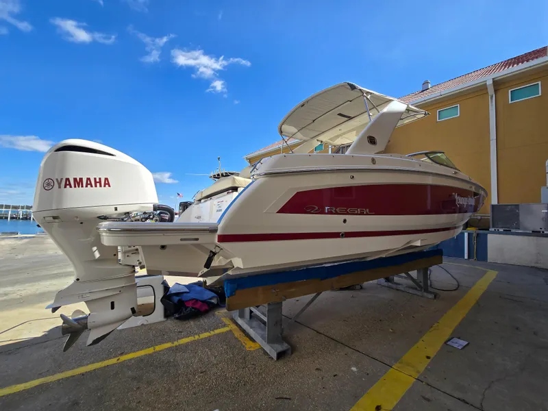 Slide: The Image of 2019 Regal 26 OBX boat with Yamaha outboard motor on a dock. - 24