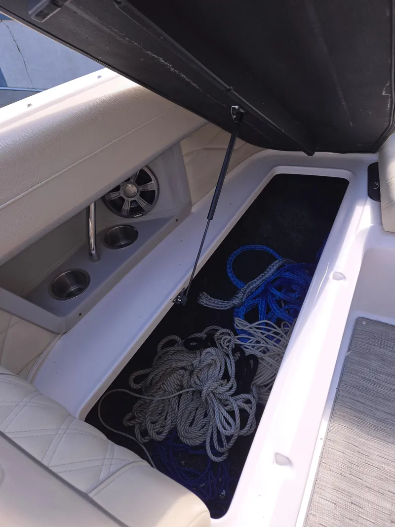Slide: The Image of 2019 Regal 26 OBX boat storage compartment with ropes and cup holders. - 34