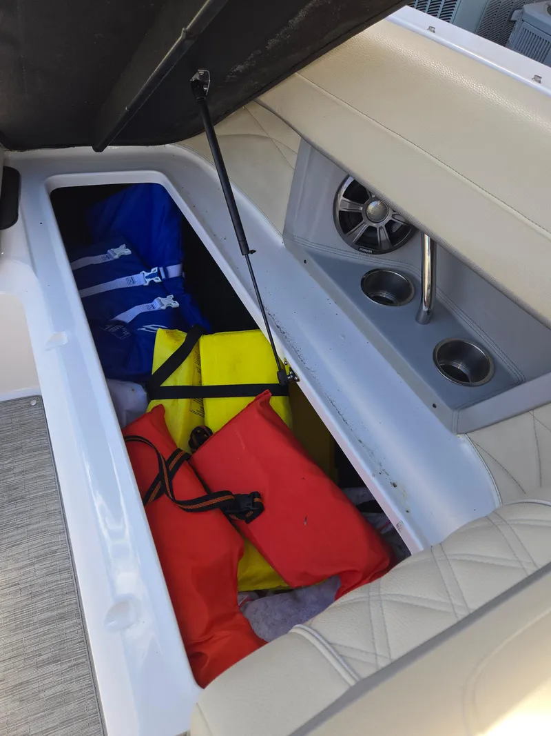 Slide: The Image of 2019 Regal 26 OBX boat storage compartment with colorful life jackets and cup holders. - 35