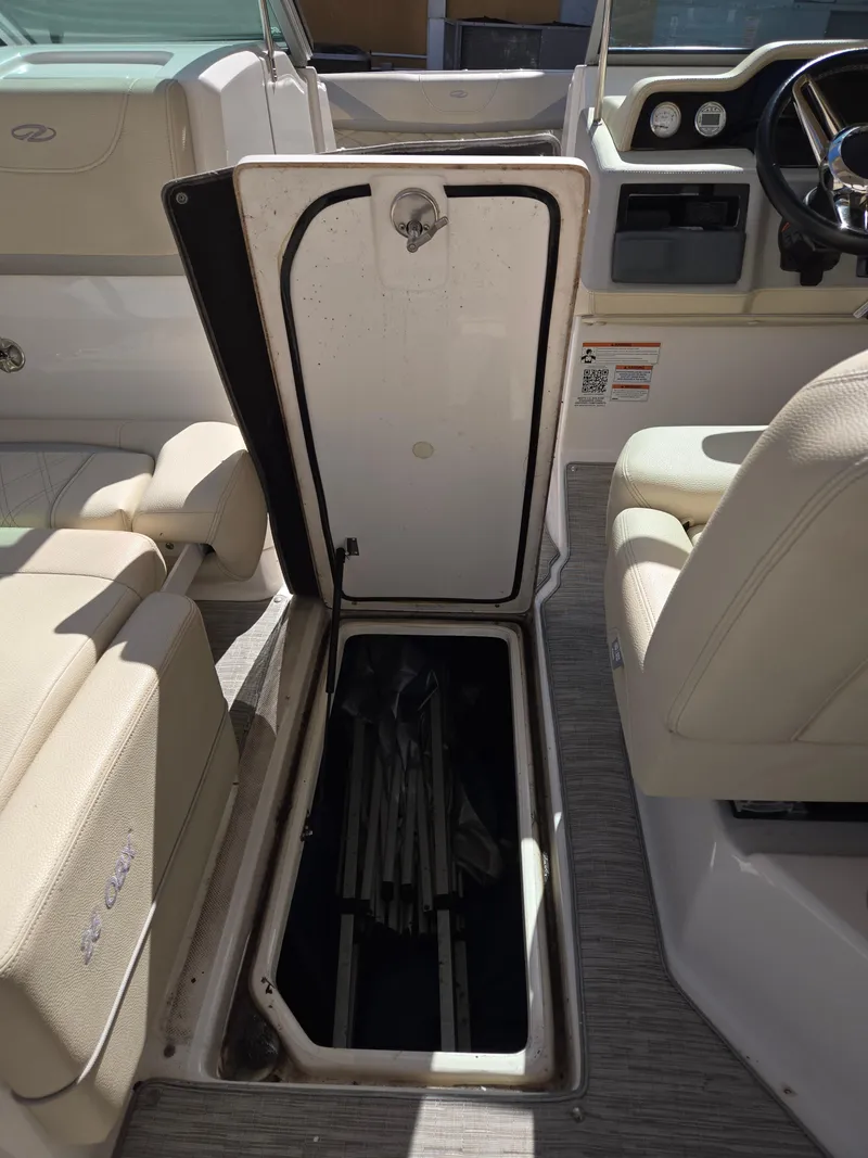 Slide: The Image of 2019 Regal 26 OBX boat interior storage compartment with open hatch and visible seating. - 37