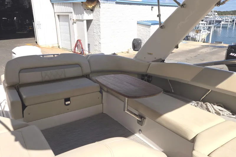 Slide: The Image of 2019 Regal 26 OBX boat interior with beige seating and wooden table. - 46