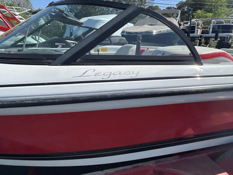 Slide: The Image of 1998 Supra Legacy boat, red and white exterior, side view. - 11
