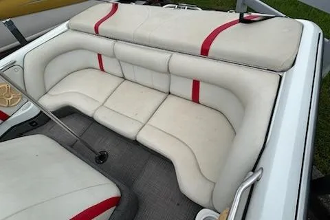 Slide: The Image of 1998 Supra Legacy boat interior with white and red cushioned seating. - 12