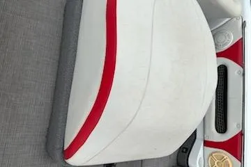 Slide: The Image of 1998 Supra Legacy boat interior with white and red seating, gray flooring, and speaker detail. - 4
