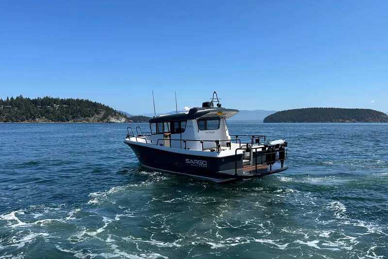 Slide: The Image of 2020 Sargo 31 boat cruising on a scenic lake with islands in the background. - 12