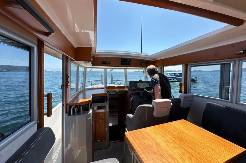 Slide: The Image of Interior of 2020 Sargo 31 boat with person at the helm, navigating on a sunny day. - 17