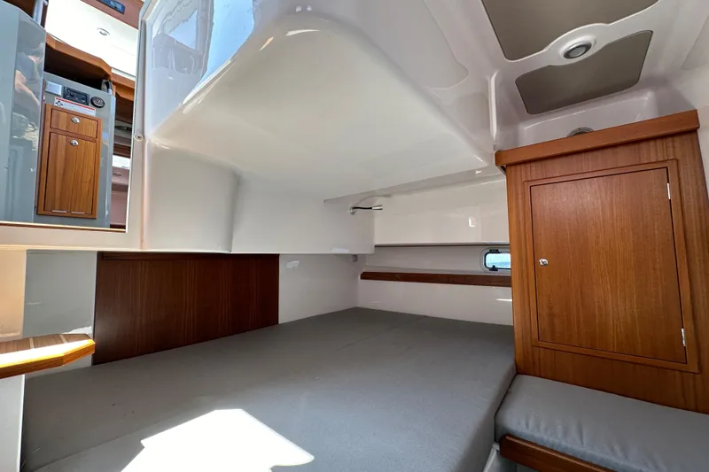 Slide: The Image of Interior cabin of 2020 Sargo 31 boat with wooden cabinetry and grey bedding. - 23