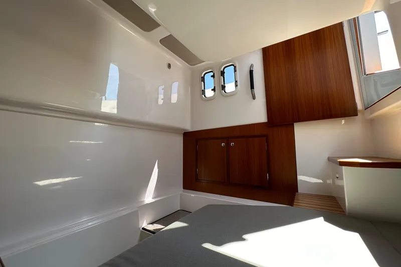 Slide: The Image of Interior cabin of 2020 Sargo 31 boat with wooden cabinets and porthole windows. - 24