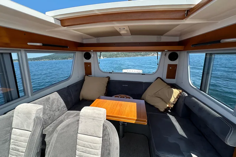Slide: The Image of Interior of 2020 Sargo 31 boat with seating area and table, overlooking the water. - 25