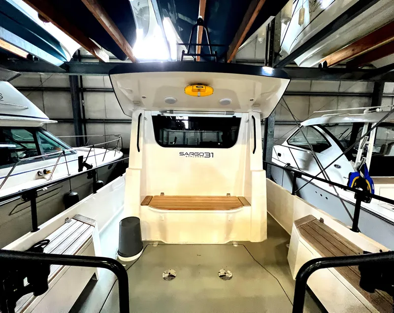 Slide: The Image of 2020 Sargo 31 boat interior, docked in a marina, showcasing seating and storage areas. - 33