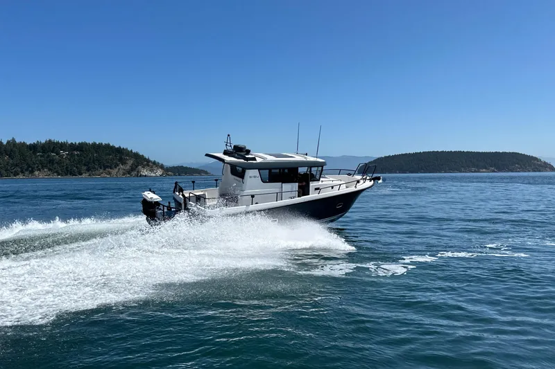 Slide: The Image of 2020 Sargo 31 boat cruising on open water with scenic island background. - 8