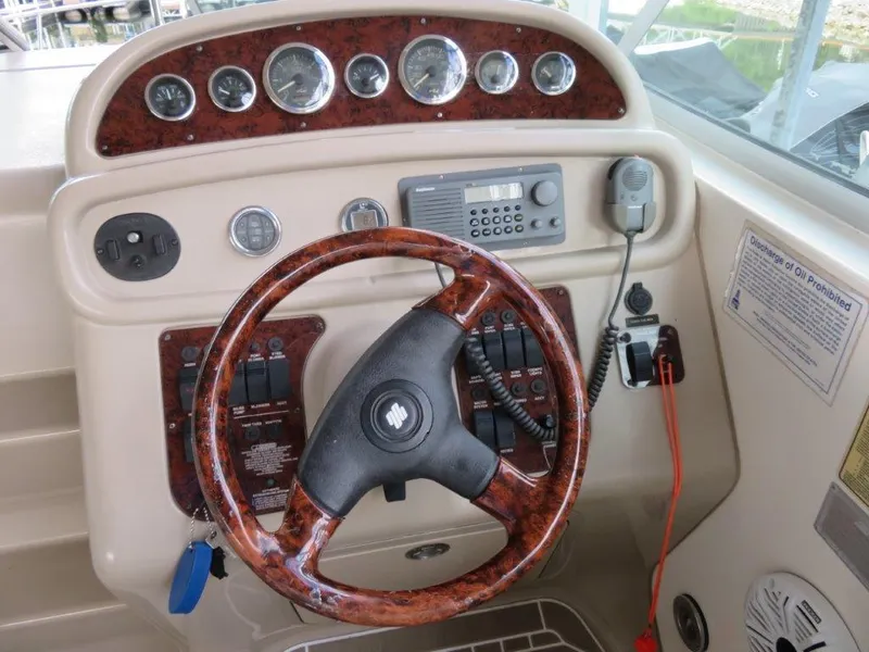 Slide: The Image of Steering console of a 2000 Sea Ray 270 DANCER boat with wood accents and gauges. - 2