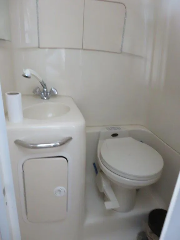 Slide: The Image of Compact bathroom in a 2000 Sea Ray 270 Dancer boat, featuring a sink and toilet. - 7