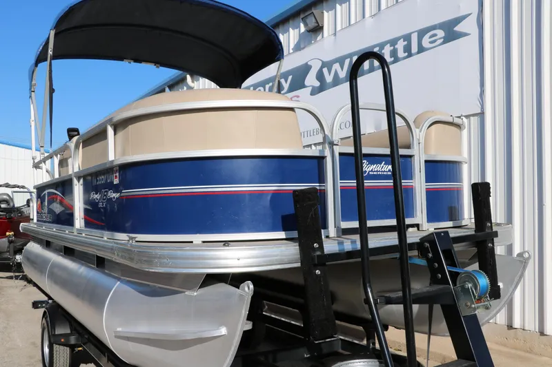 Slide: The Image of 2016 Sun Tracker Party Barge 18 DLX pontoon boat on trailer, blue and beige. - 12