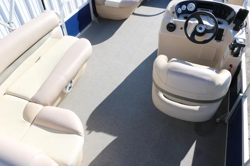 Slide: The Image of Interior of 2016 Sun Tracker Party Barge 18 DLX pontoon boat with beige seating and steering console. - 22