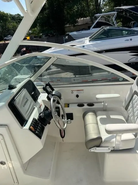 Slide: The Image of 2021 World Cat 230DC boat interior with steering wheel and seating. - 12