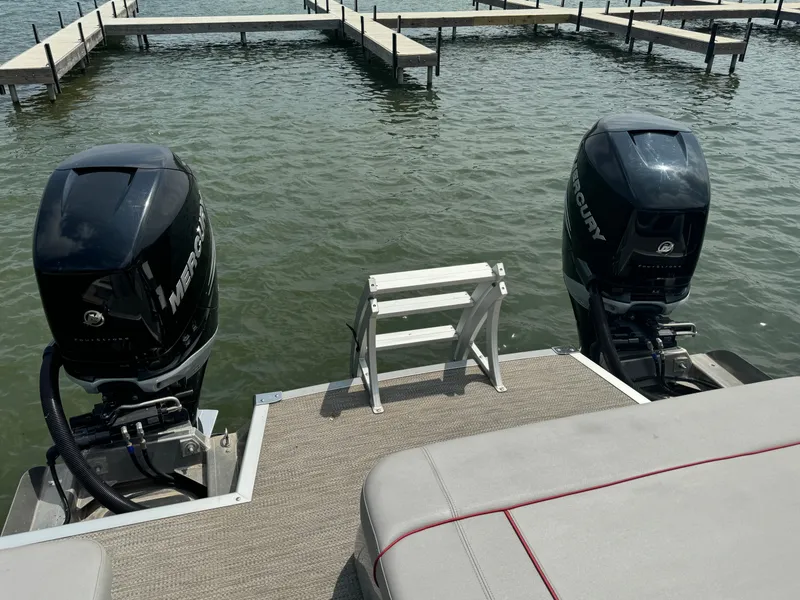 Slide: The Image of 2020 Bennington QSBWAX2SG boat with twin Mercury outboard engines at dock. - 13