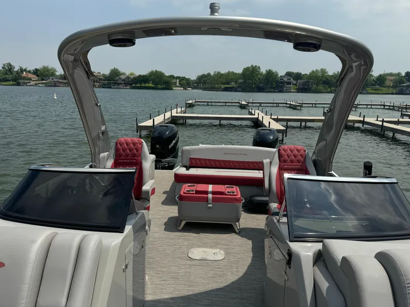 Slide: The Image of 2020 Bennington QSBWAX2SG pontoon boat with red and white seating on a lake. - 7