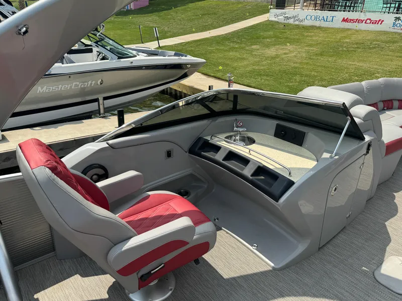 Slide: The Image of 2020 Bennington QSBWAX2SG boat interior with red and gray captain's chair and control console. - 8