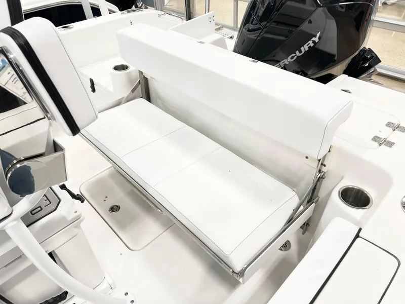 Slide: The Image of 2024 Sea Pro 222 Center Console boat interior with white seating and Mercury engine. - 8