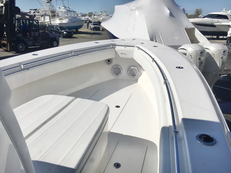 Slide: The Image of 2024 Contender 32 ST boat interior with seating and speakers, docked among other vessels. - 13