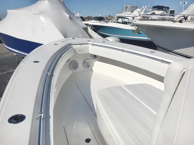 Slide: The Image of 2024 Contender 32 ST boat interior with white seating and sleek design in a marina setting. - 15