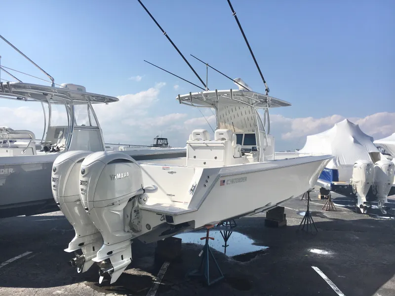 Slide: The Image of 2024 Contender 32 ST boat with dual engines, displayed outdoors under a clear sky. - 2