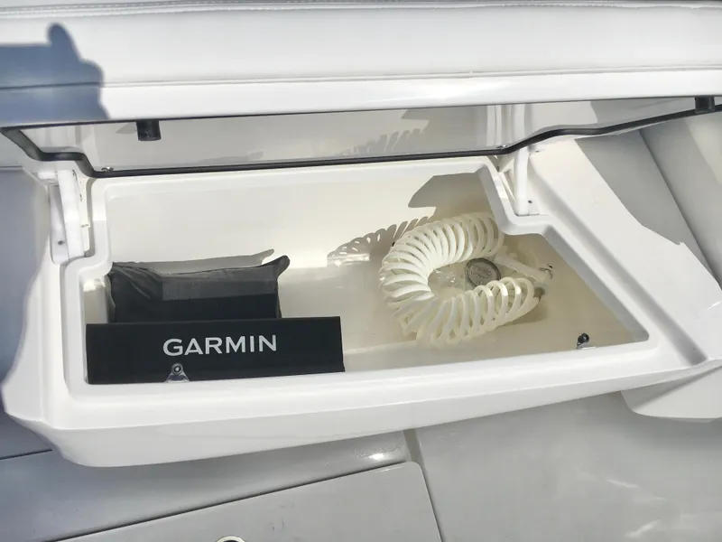 Slide: The Image of 2024 Contender 32 ST boat compartment with Garmin equipment and coiled hose. - 21