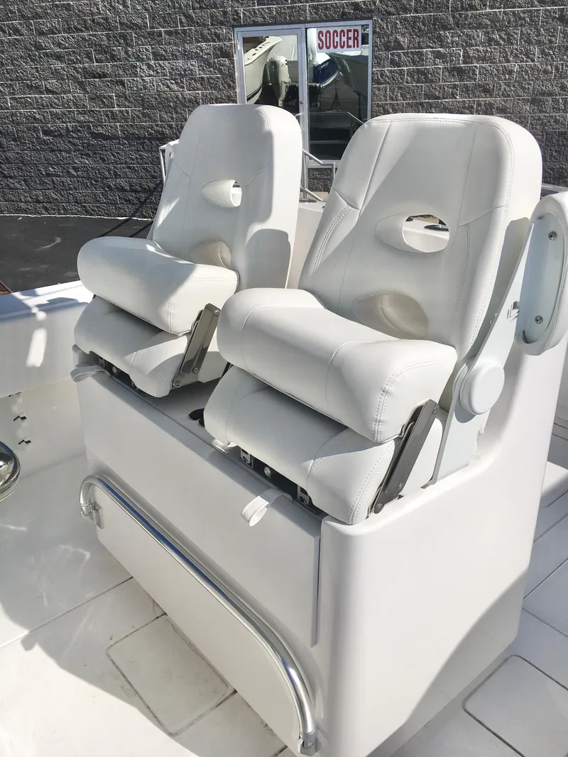 Slide: The Image of 2024 Contender 32 ST boat seats, white leather, modern design, outdoor setting. - 26
