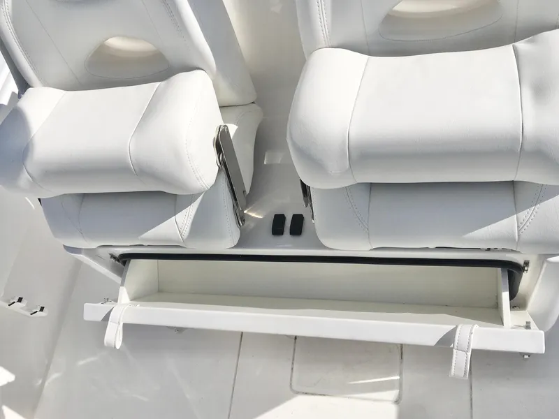 Slide: The Image of 2024 Contender 32 ST boat interior with white cushioned seats and storage compartment. - 27
