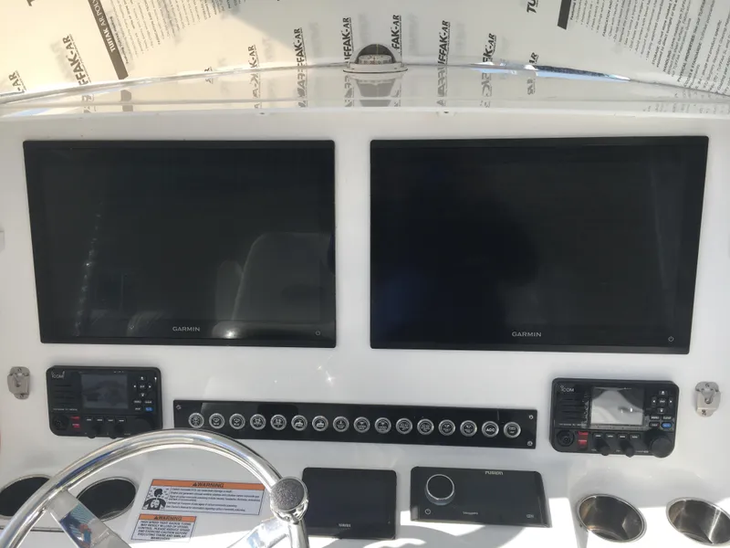 Slide: The Image of 2024 Contender 32 ST boat dashboard with dual Garmin screens and control panel. - 29