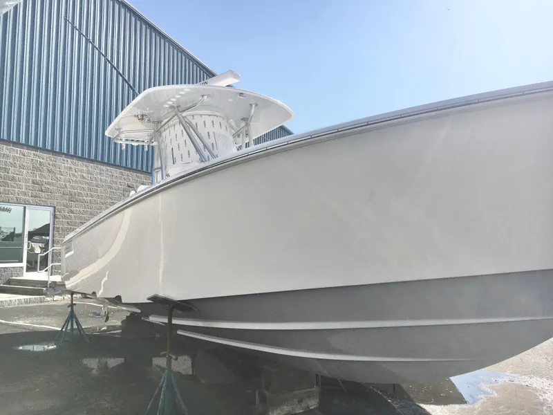 Slide: The Image of 2024 Contender 32 ST boat on stands outside a warehouse. - 3