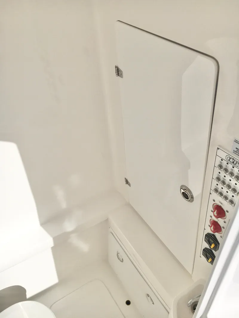 Slide: The Image of 2024 Contender 32 ST interior with control panel and storage compartment. - 37